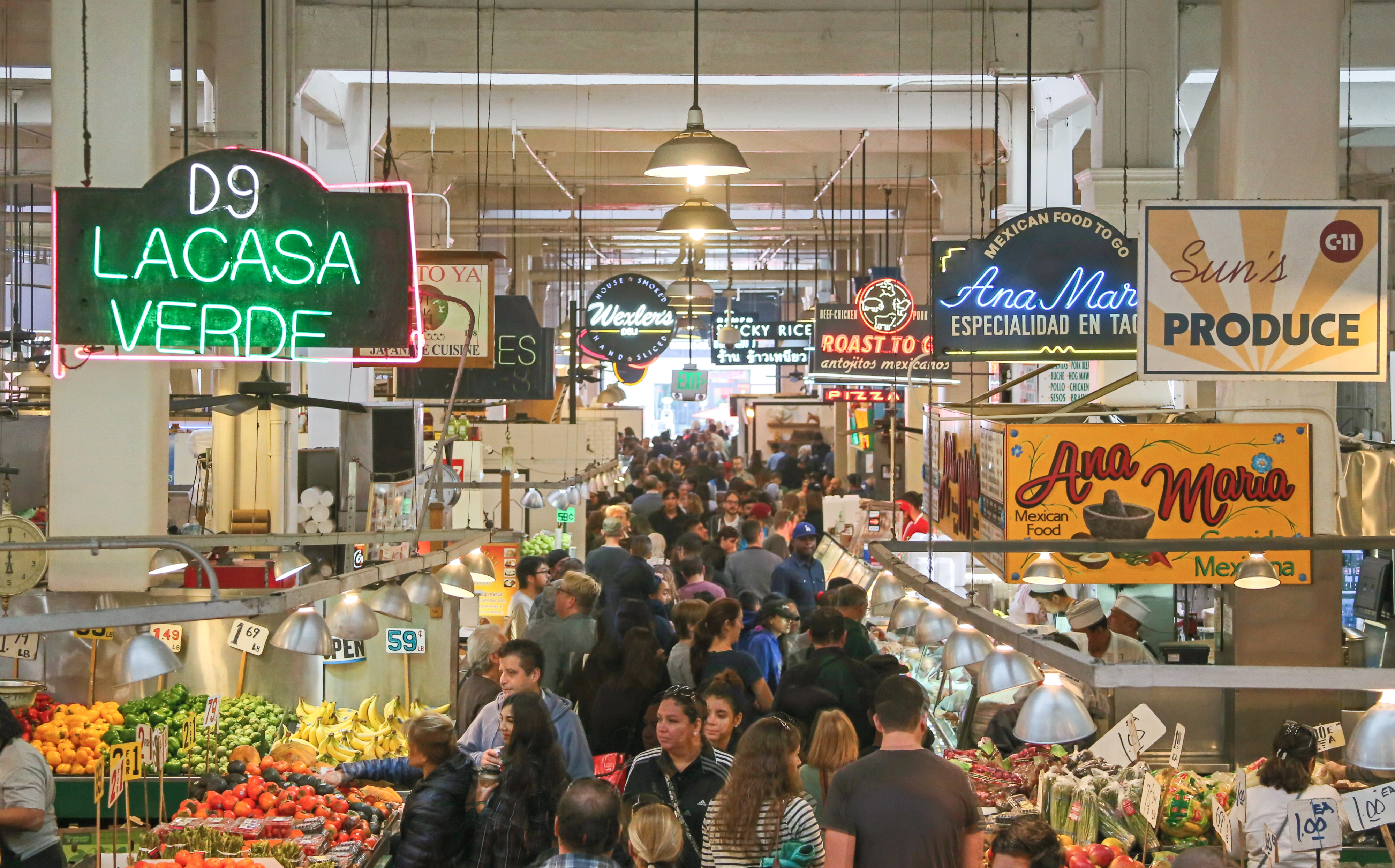 Los Angeles, United States - November 28, 2015: A view looking down into the Grand Central Market in historic downtown Los Angeles. Here you can find a large variety of food stands and stalls selling groceries and other food related items. Located in the historic Homer Laughlin building, it features a large open space for shopping and browsing and various neon signs advertising foods traditionally found in California. People can be seen shopping and sitting at counters eating meals.